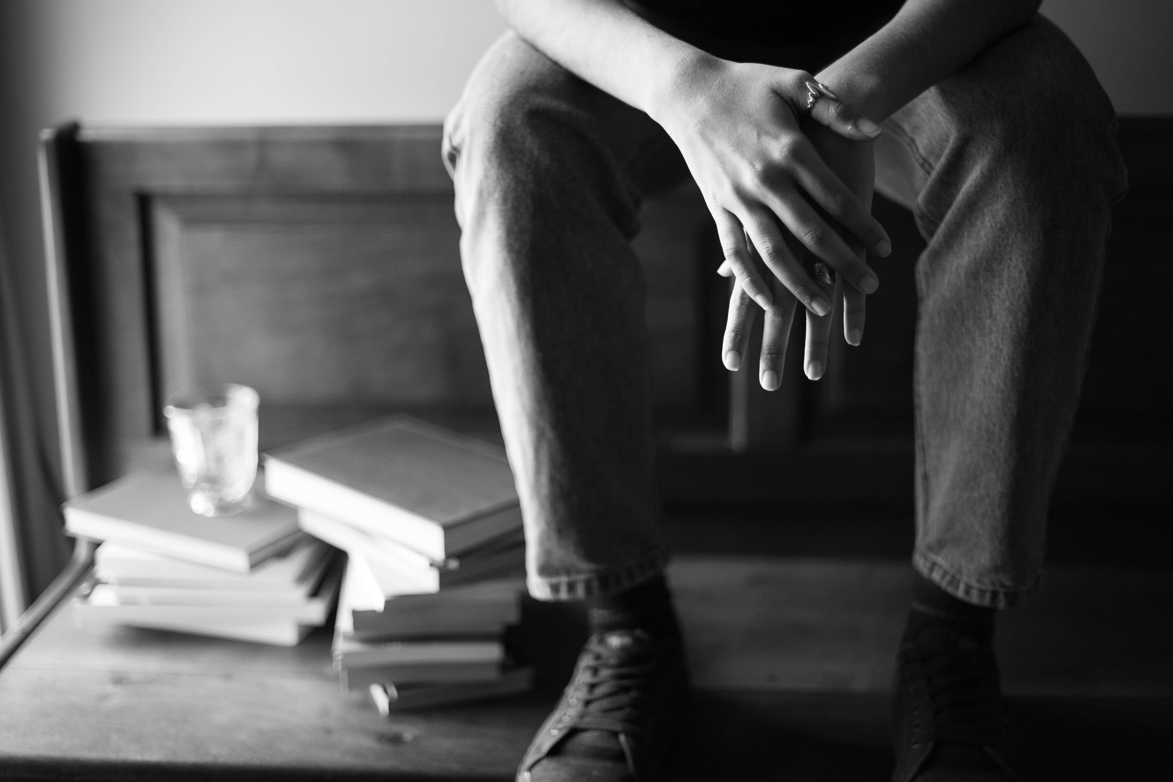 Mesa de escritura íntima junto a una ventana con libro, papeles y luz cálida